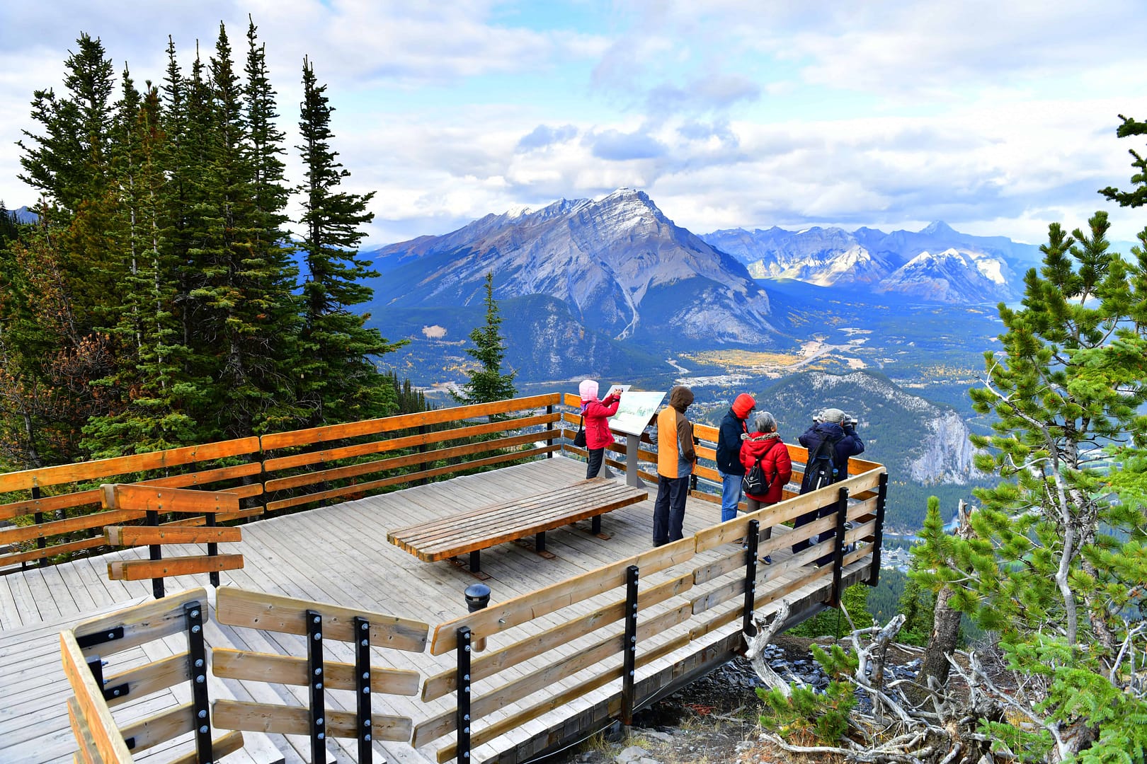 A group of people in Alberta standing on a wooden deck overlooking tracks in the distance.