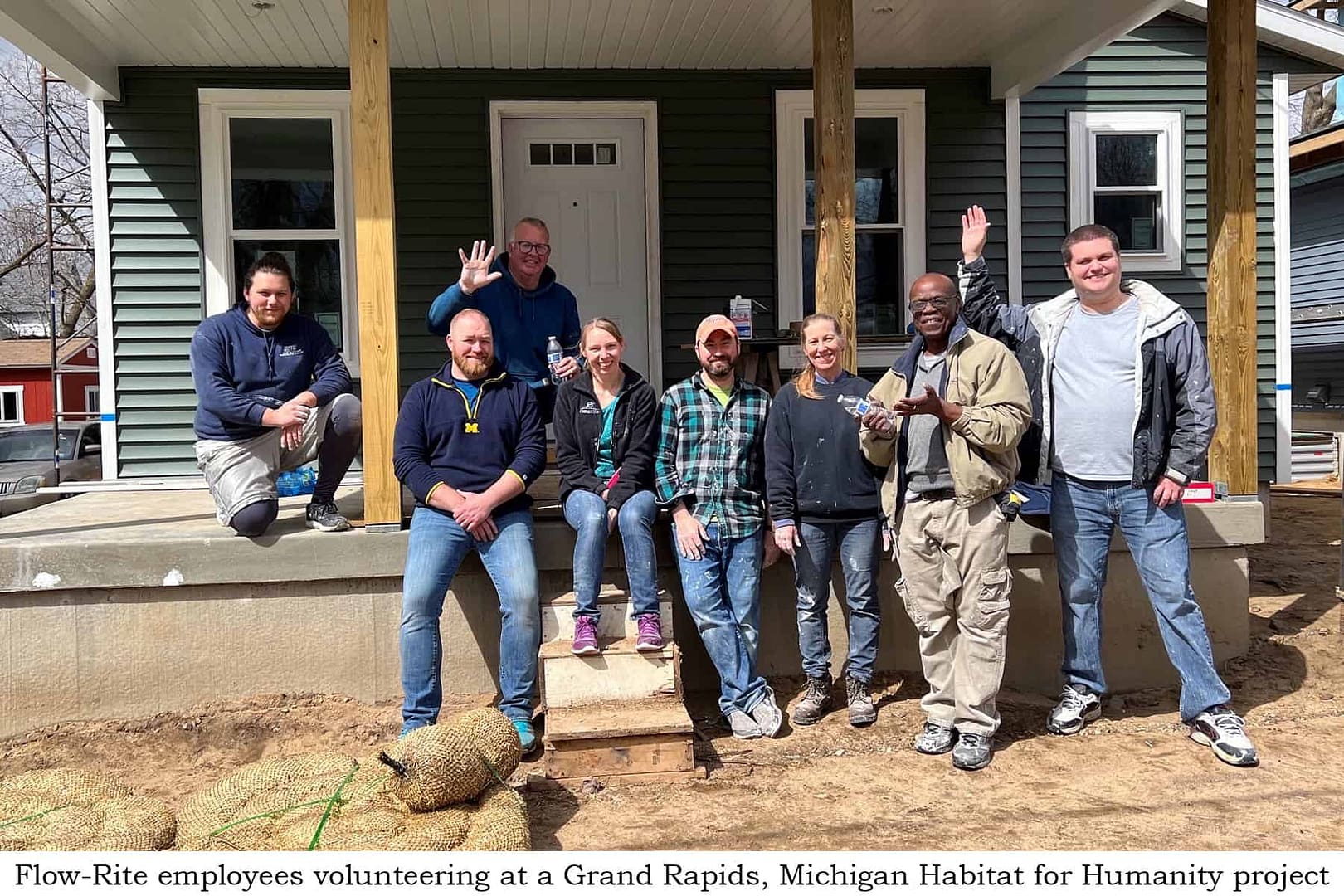 A team of Volunteer Team Members standing in front of a house.