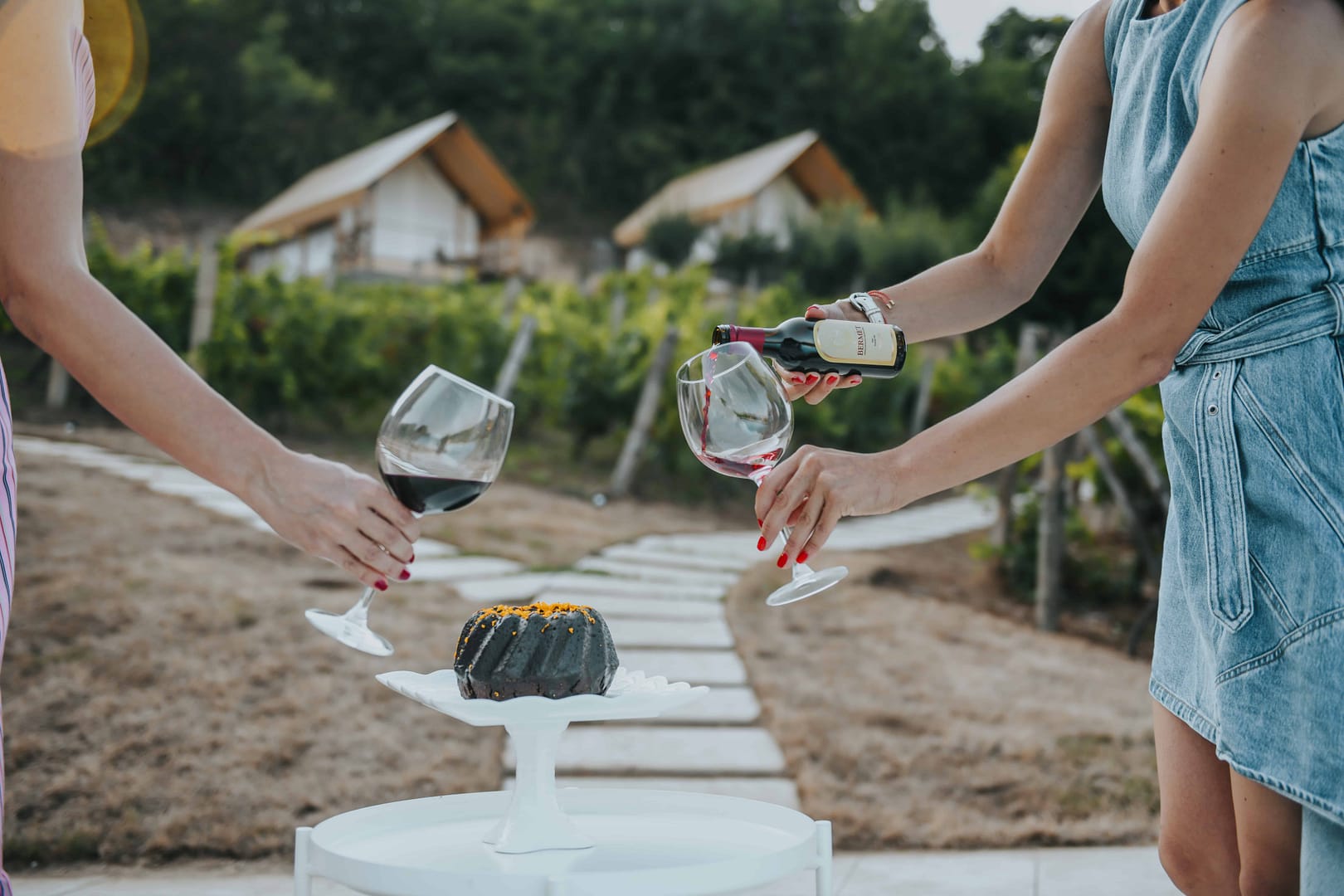 Two women toasting wine glasses in a vineyard at the FRVCA registration event in 2023.