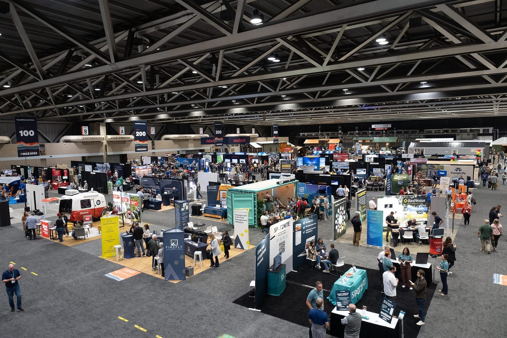 An aerial view of a large convention hall during OHCE2023 with people walking around.