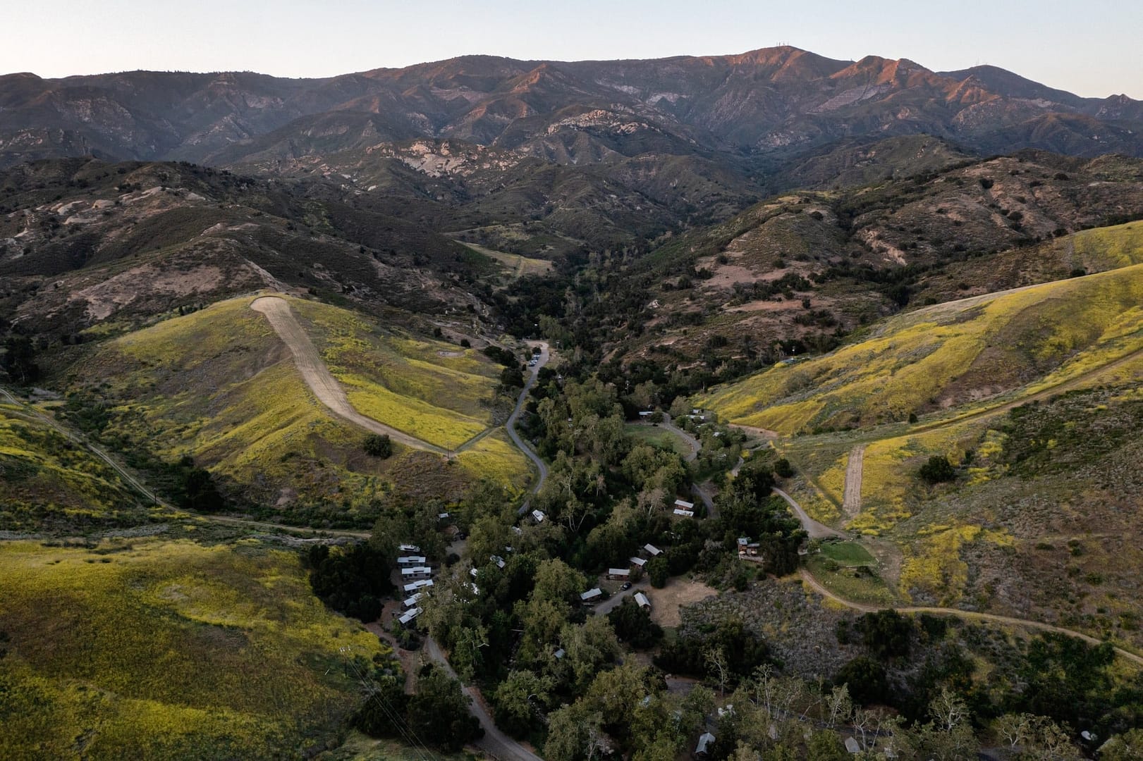 An aerial view of El Capitan Canyon Campground nestled in a picturesque mountain valley.