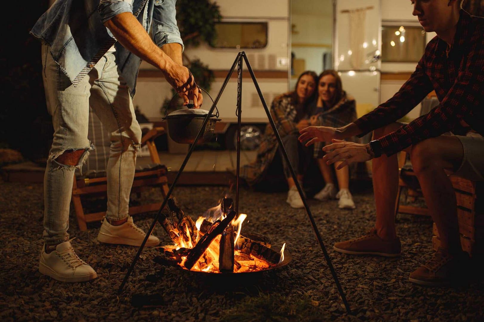A group of people sitting around a campfire at night, enjoying the warm glow and camaraderie in the presence of Pikes Peak.