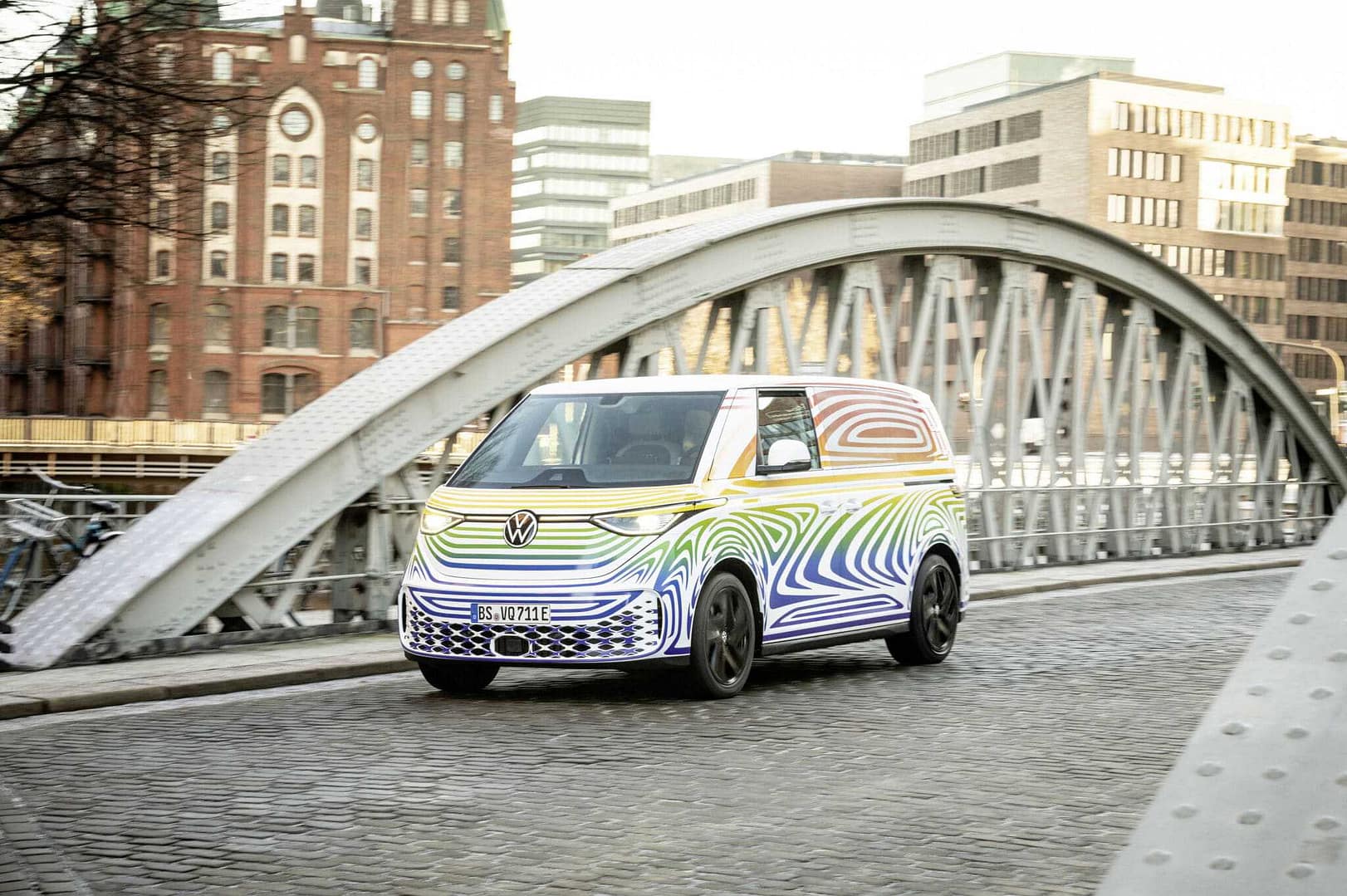 A colorful Volkswagen ID. Buzz van is driving on a bridge at SXSW.