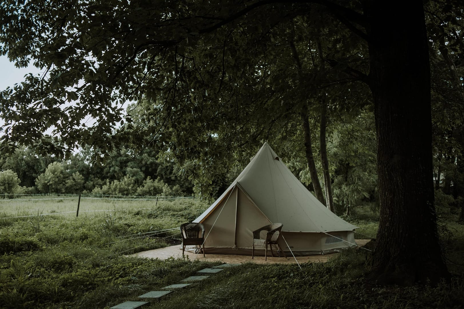 In the middle of a wooded area, a white tent sits, showcasing plans for a glamping site near the Star Inn Pub.