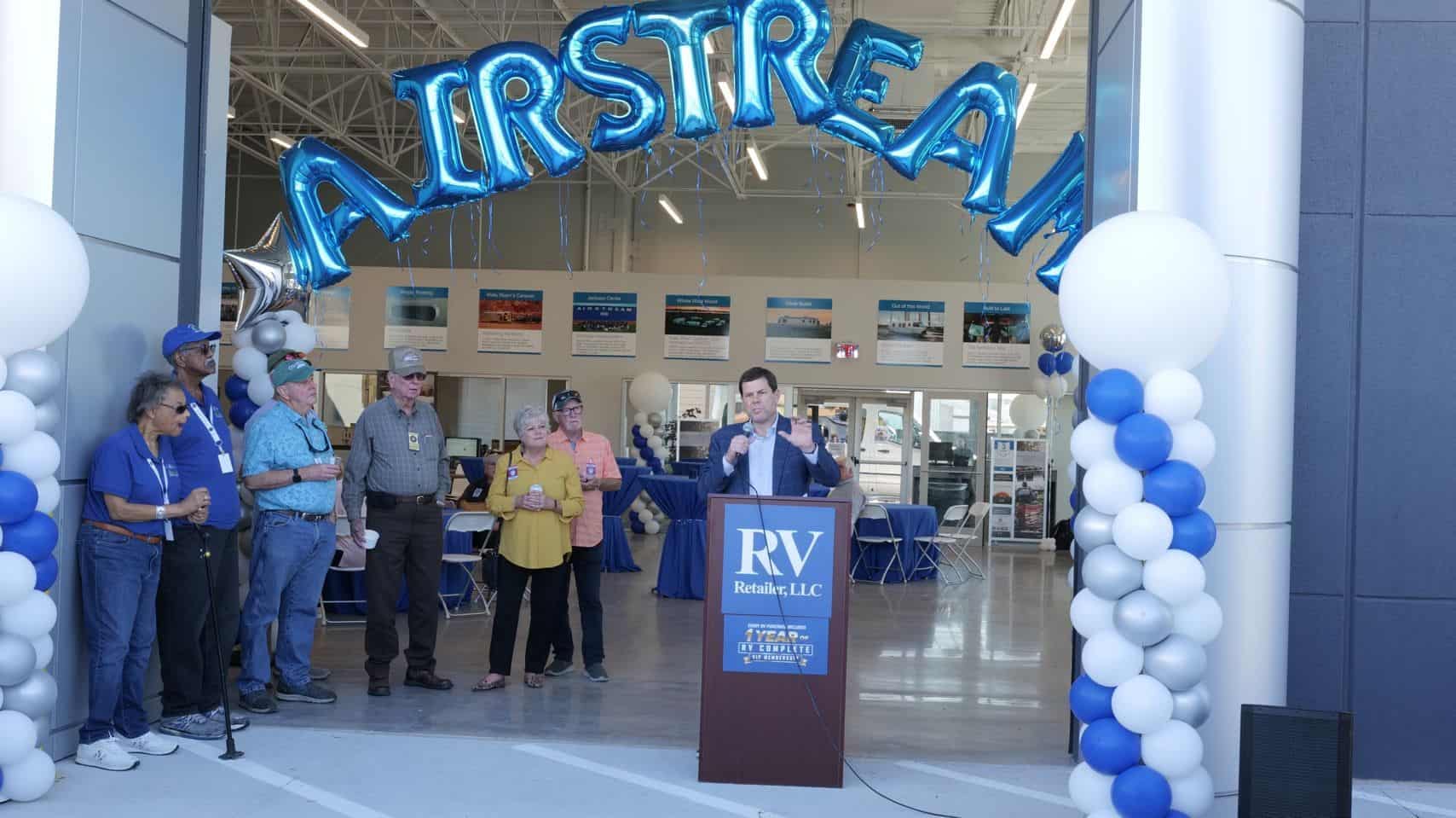 A group of people standing at a podium in front of one of the country's largest airstream stores in Austin.