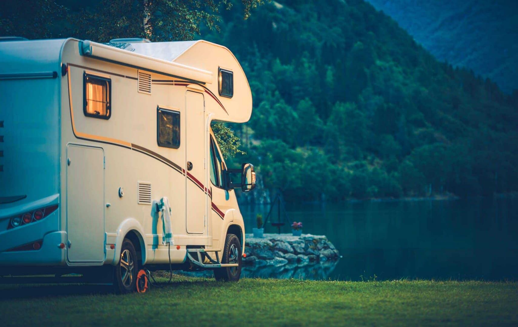 An RV parked in front of a lake.