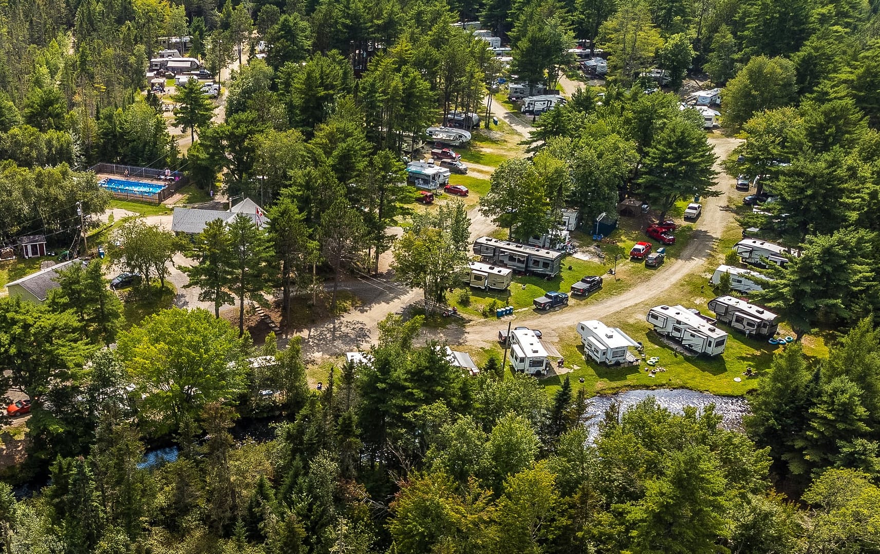 An aerial view of RayPort Campground, amidst a forest, potentially undergoing evacuation due to flooding.