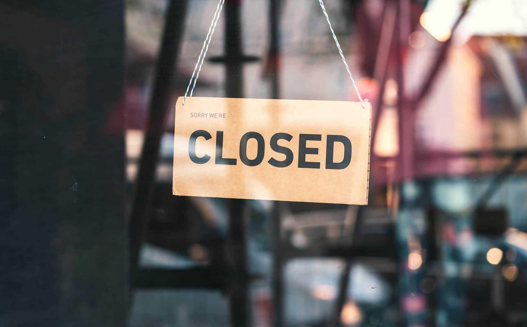 A closed sign hanging from the window of a business.