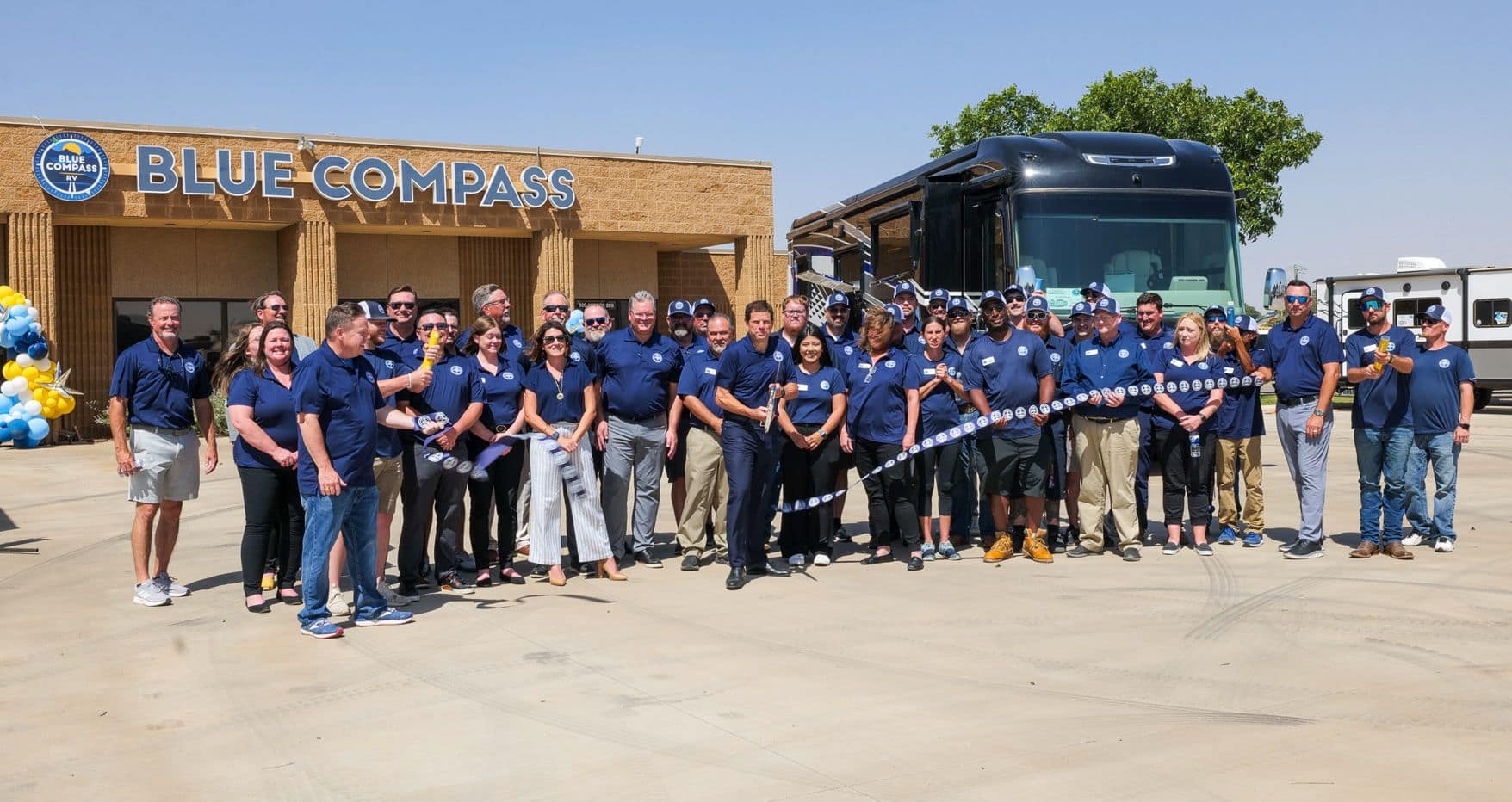A brand rollout event for Blue Compass RV in Texas, showcasing a group of people standing in front of a blue horizons dealership.