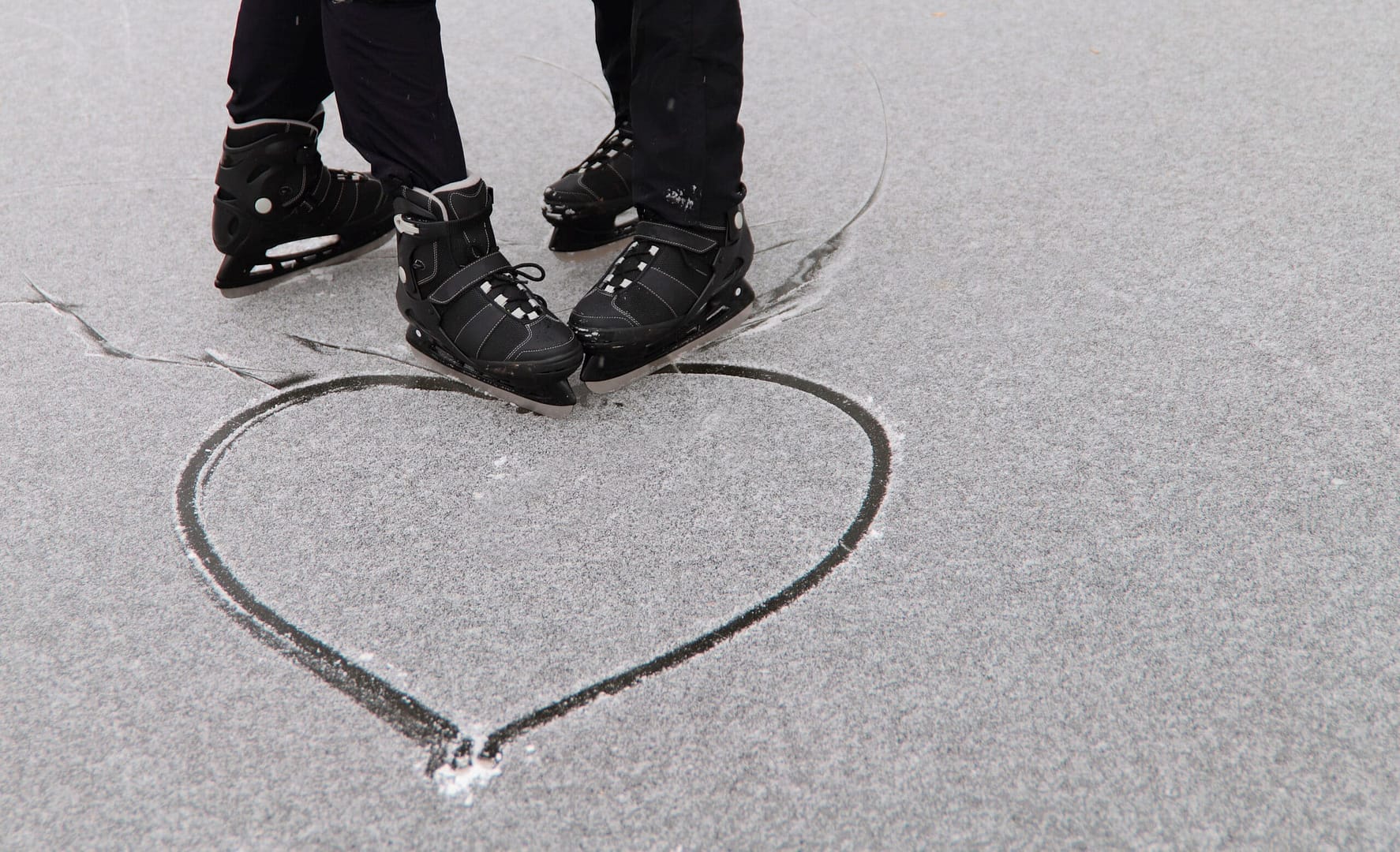 Two people on ice skates at the Heart-Embedded Ice Rink in the shape of a heart.