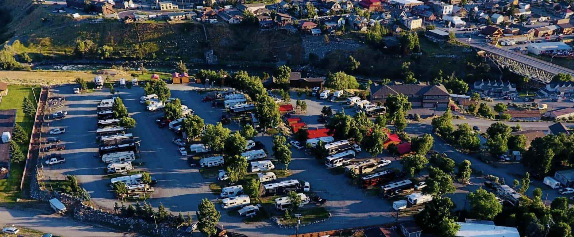 An expansive aerial view of a property featuring an RV park surrounded by the mesmerizing blue water.