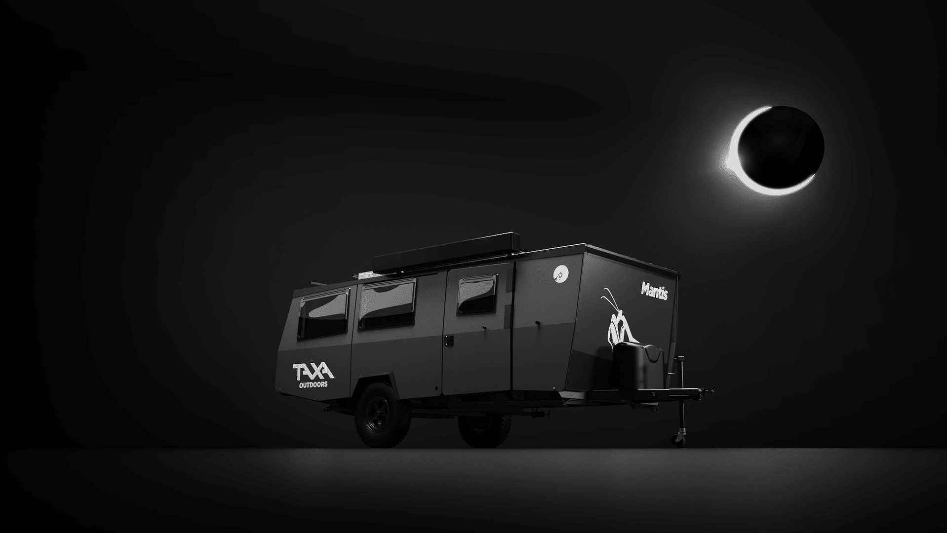 A black camper trailer with Auto Draft white branding parked under a dim light against a dark background.