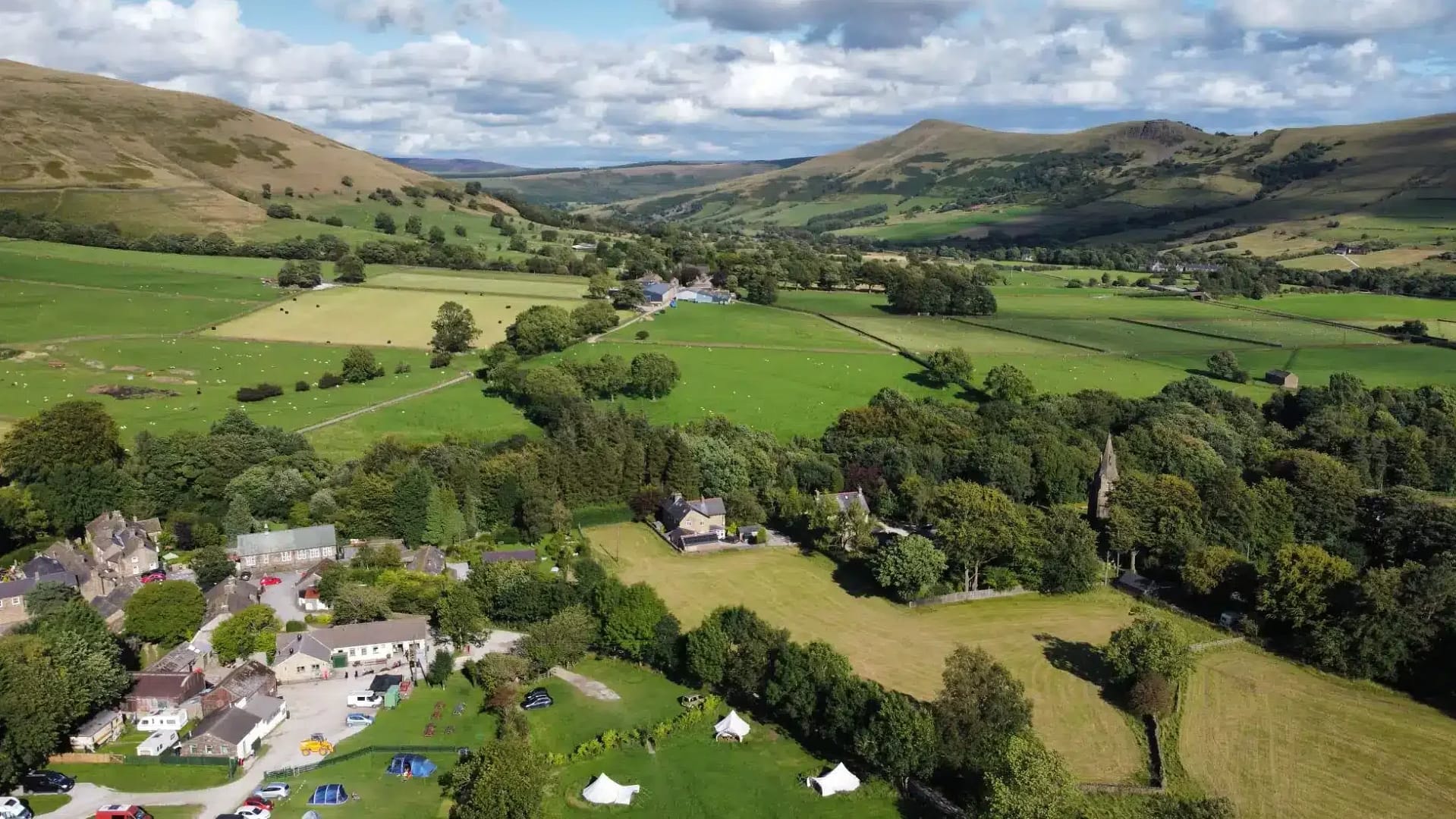 An aerial view of Newfold Farm, a premier camping destination nestled in the mountains.