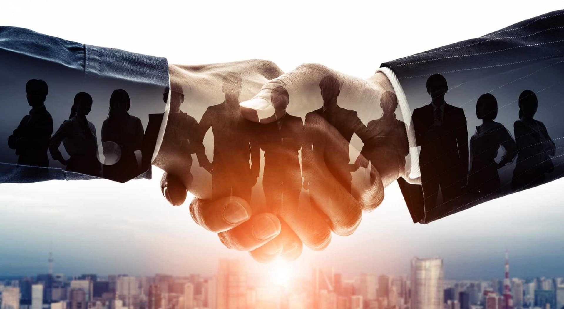 A group of business people shaking hands in front of the city.