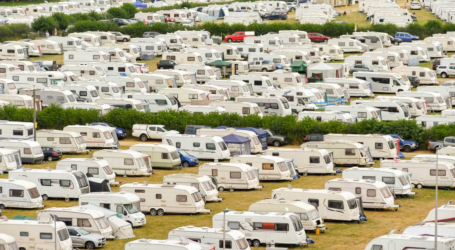 Many RVs parked in a field during a Caravan Supershow.