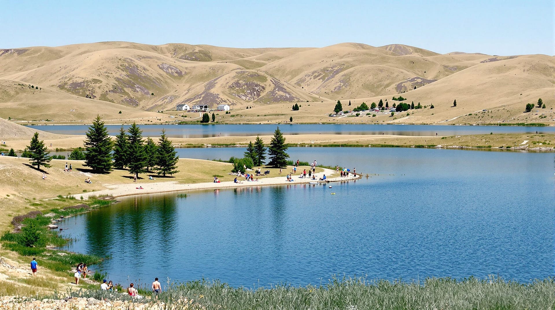 A sunny day at a reservoir with people enjoying outdoor activities along a shoreline, surrounded by rolling hills and evergreen trees.