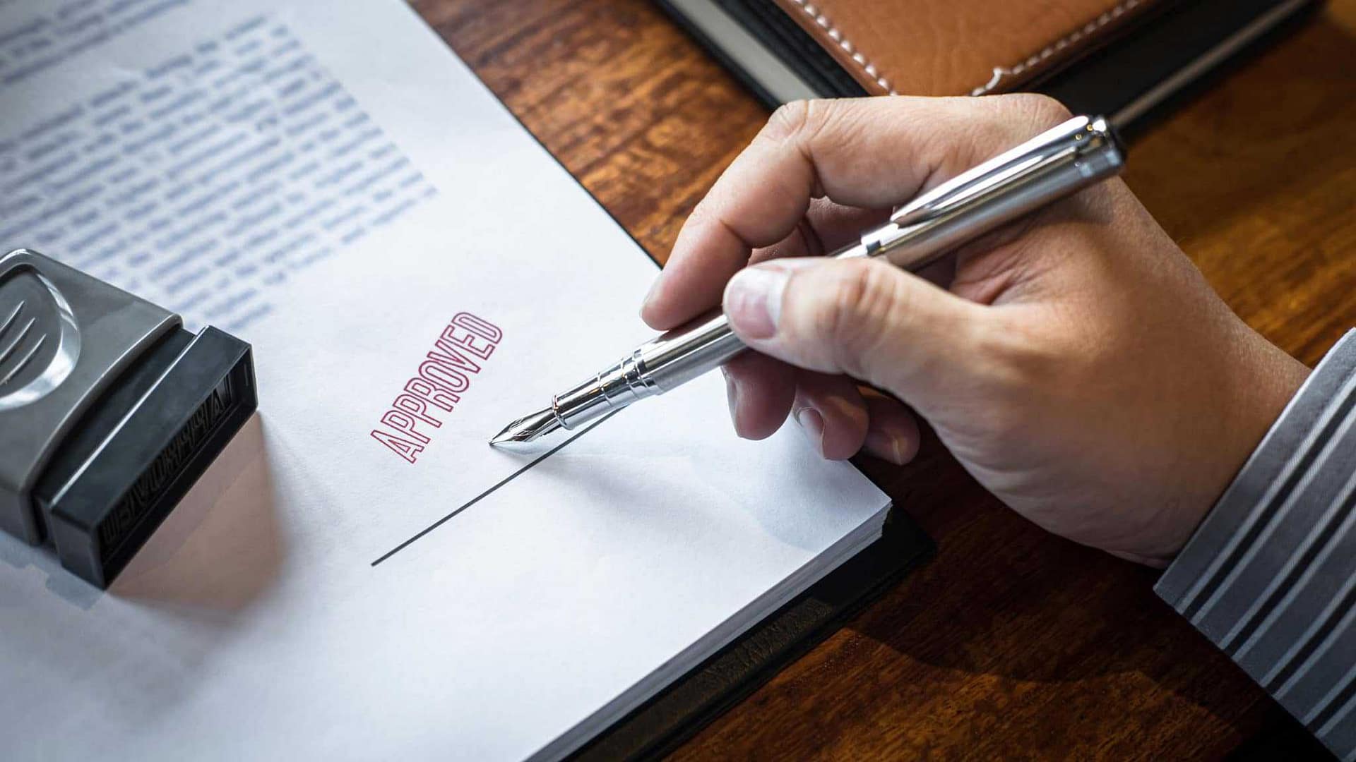 A person signing a document with a pen at an Alberta campground.