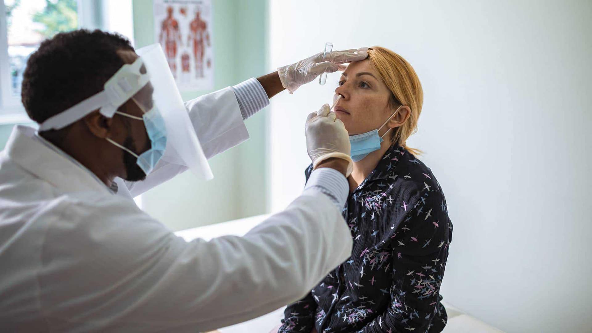 A doctor is giving a woman a vaccine.