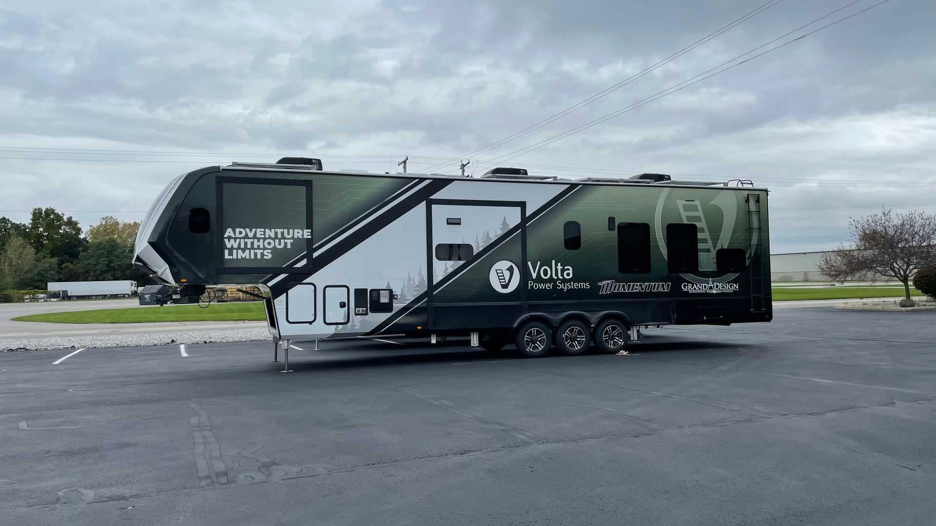 A luxurious black and white Grand Design RV parked in a parking lot.