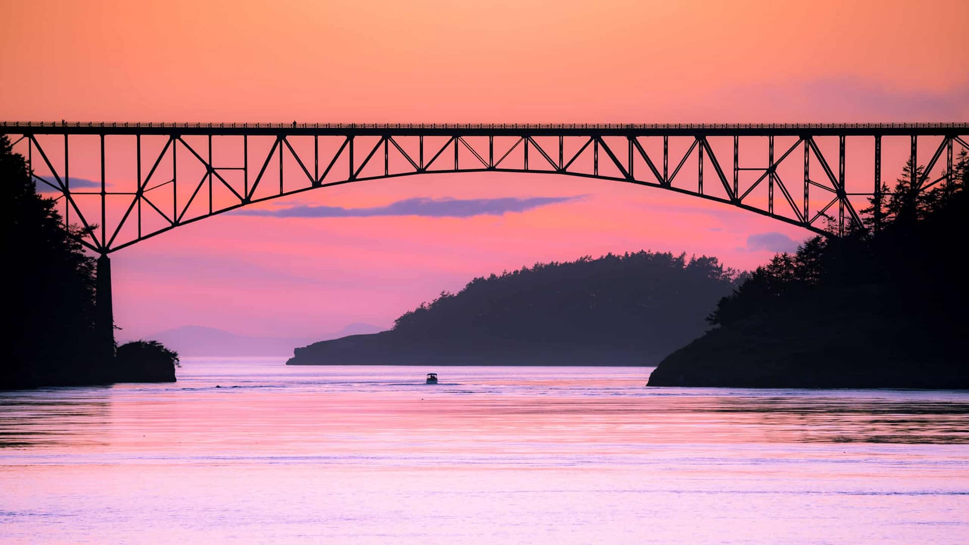 Deception Pass State Park celebrates its centennial year with a mesmerizing bridge over a body of water at sunset.