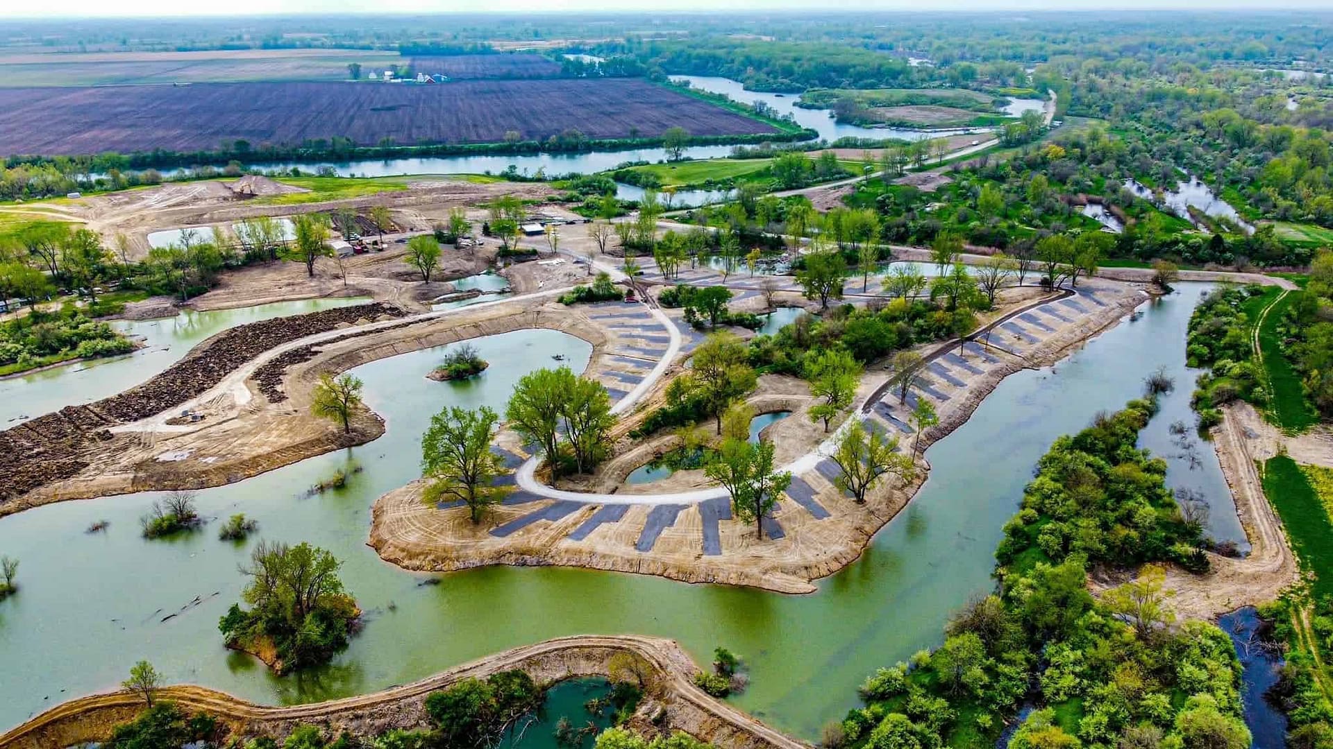 An aerial view of a pond in a rural area, located at the Giant Goose Ranch.