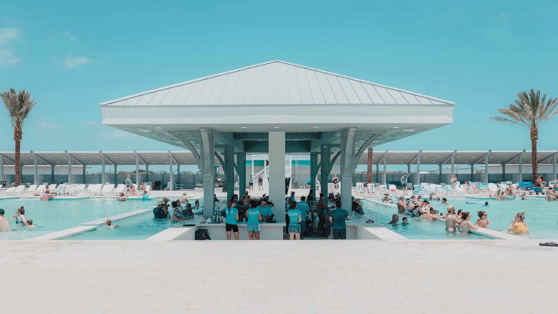 A group of people standing in front of a pool at Bolivar Beach Club, enjoying the 4th of July festivities.