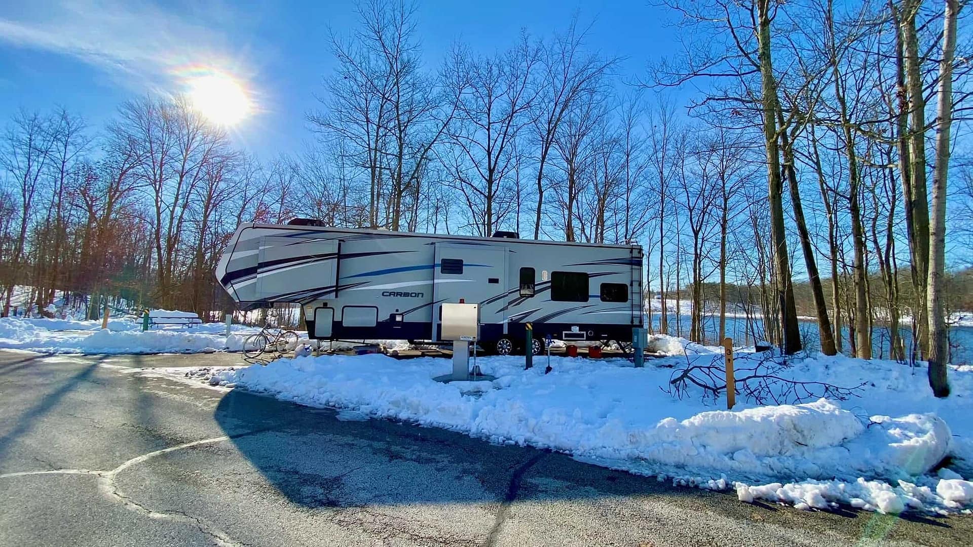 An upgraded snow covered RV parked in Punderson State Park.