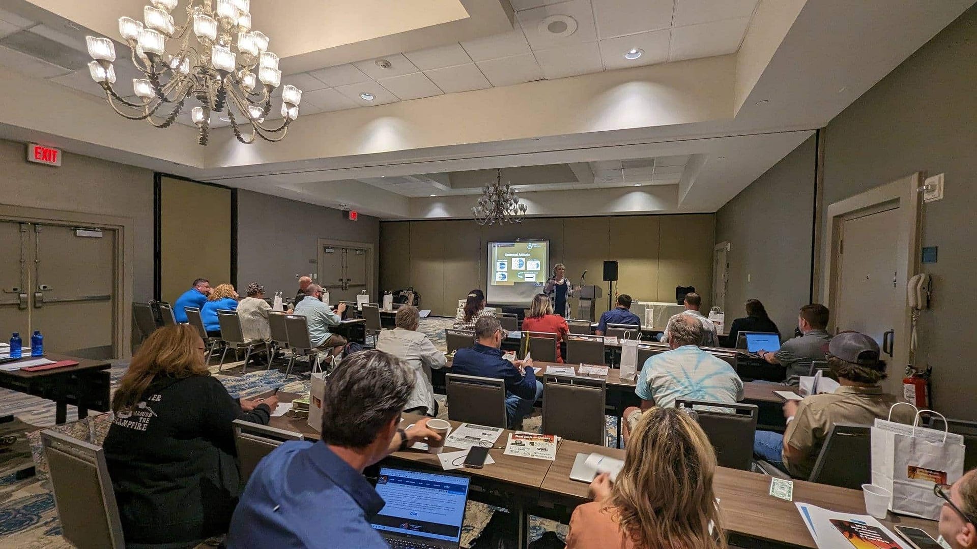 A group of people sitting at tables in a conference room, gathered for the Mid-Atlantic Campground Conference taking place in 2024.