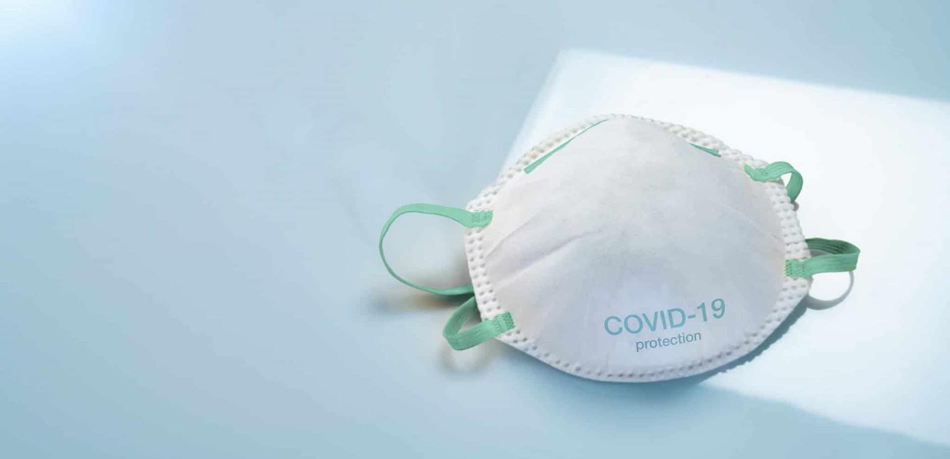 A white face mask with the word covid-19 on it.
