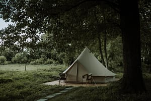In the middle of a wooded area, a white tent sits, showcasing plans for a glamping site near the Star Inn Pub.