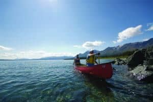 Two people paddling a canoe on a lake at Congdon Creek Campground.