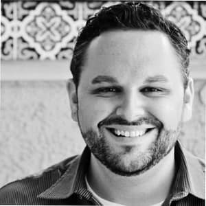 A black and white photo of a man smiling, representing Horizon Outdoor Hospitality.