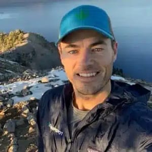 A man is taking a selfie on top of a mountain during the MC Fireside Chats event on December 7th.