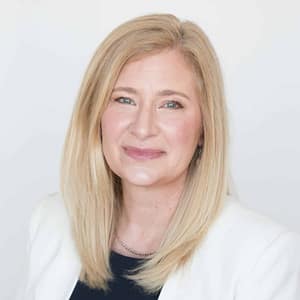 On December 21st, 2022, a woman in a white blazer strikes a pose for a photo during the MC Fireside Chats event.