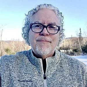 A man in glasses standing in the snow during MC Fireside Chats on November 1st, 2023.