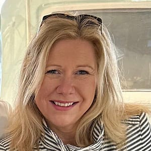 A woman is smiling while sitting on a boat during the MC Fireside Chats on February 28th, 2024.