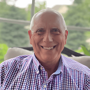 An older man smiling in a plaid shirt at the MC Fireside Chats on March 6th, 2024.