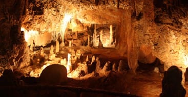 A group of people are standing inside the Endless Caverns.