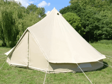 A beige tent with a rope attached to it set up in a grassy field perfect for Norfolk glamping.