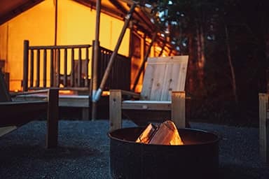 A fire pit in front of a tent at night at Terramor Outdoor Resort.