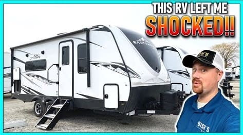 A man is standing next to a 2022 travel trailer RV.