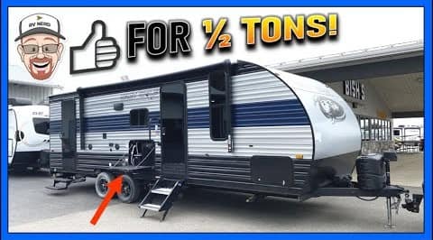 A black and white Forest River Cherokee travel trailer with the words "4 ton's" on it.