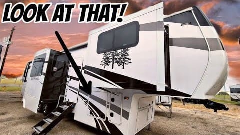 A luxurious Fifth-Wheel Redwood 3951MB parked in a lot with a sign that says look at that.