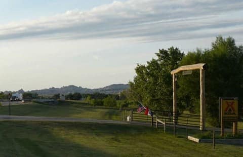 The entrance to the Badlands/White River KOA Holiday campground with a sign on it.