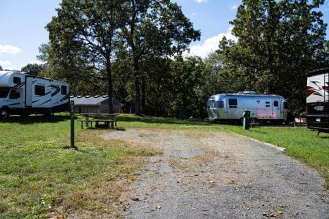 A group of RVs parked at Lake Fairfax Campground, nestled in a wooded area.
