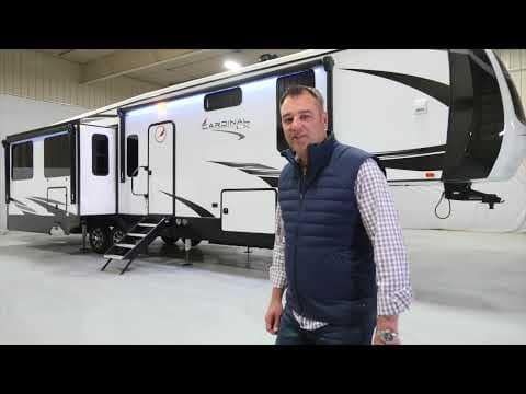 A man standing in front of a Cardinal 360RLX RV.