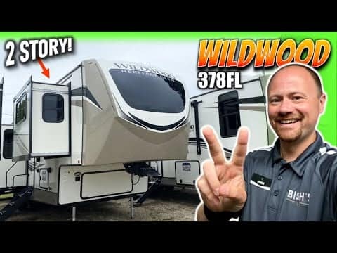 A man is standing next to a Forest River RV.