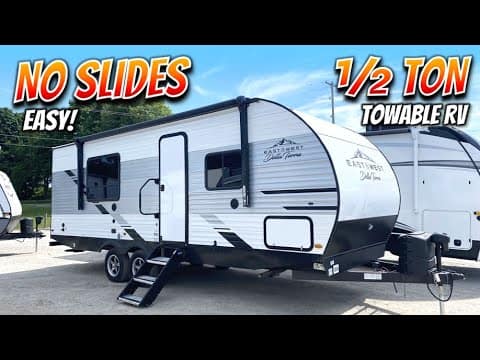 A spacious Della Terra 230RB RV with a sign that says no slides, towable rv, and is white and black.