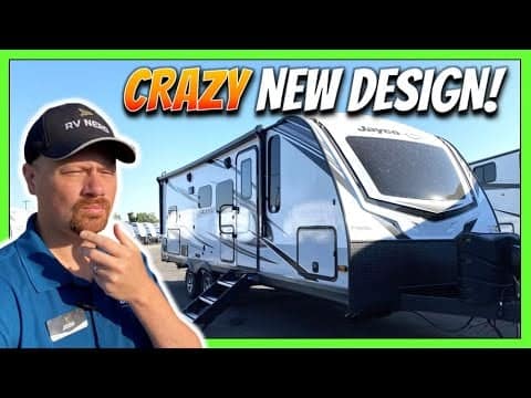 A man is standing in front of a lightweight trailer with the words crazy new design.