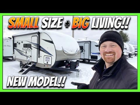 A man is standing in front of a 2023 Heritage Glen RV, experiencing the joys of downsized living with big comfort and spaciousness.